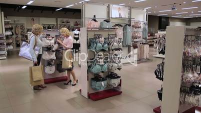 Shopaholics women selecting sexy lingerie in shop