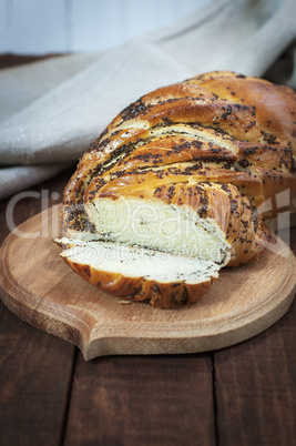 Sweet bun with poppy seeds on a kitchen cutting board