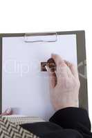 Hands with sheet of paper on clipboard
