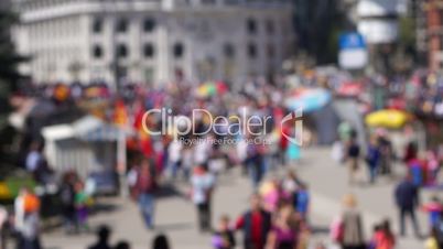 Unrecognizable, out of focus people walking in the city square