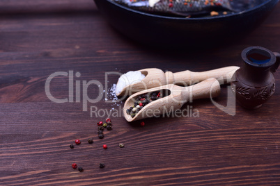 Mixture of black and red pepper in a wooden spoon