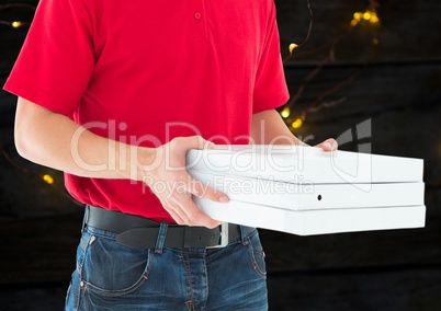 Deliveryman with pizza boxes in foreground. Wood and lights background