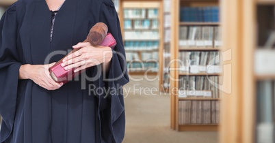 Judge holding book in front of library book shelves