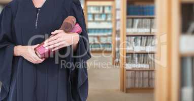 Judge holding book in front of library book shelves