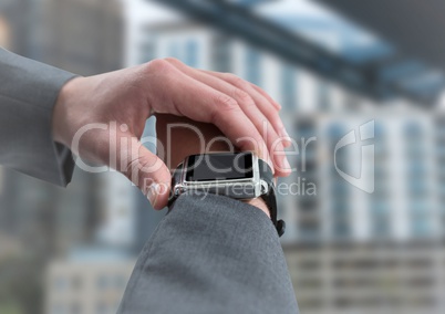 Hand with watch against blurry building