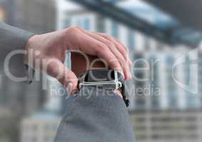 Hand with watch against blurry building