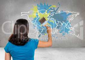 Woman painting a Colorful Map with paint splattered wall background