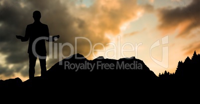 Silhouette businessman standing on hill against sky during sunset