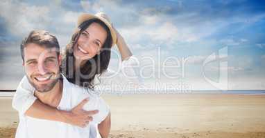 Happy man piggybacking woman at beach