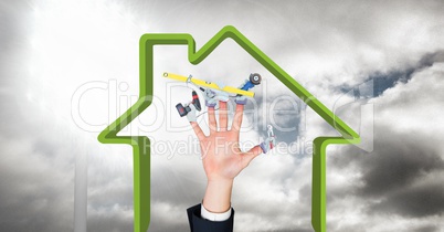 Digital composite image of hand with tool in house shape against sky