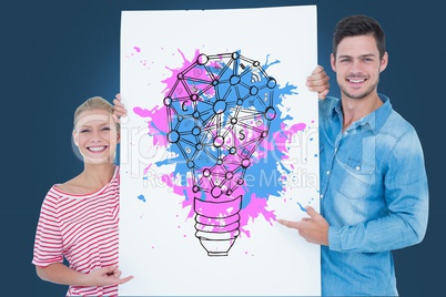 Portrait of couple holding billboard with colorful light bulb icon against blue background