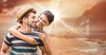 Happy man giving piggyback ride to woman at beach