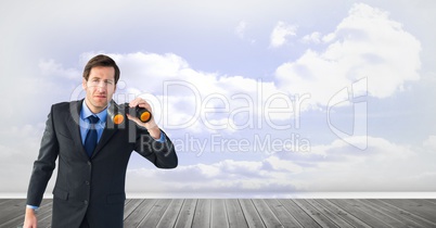 Businessman holding binoculars on boardwalk against sky