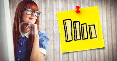 Woman at computer and yellow sticky note with graph against blurry wood panel