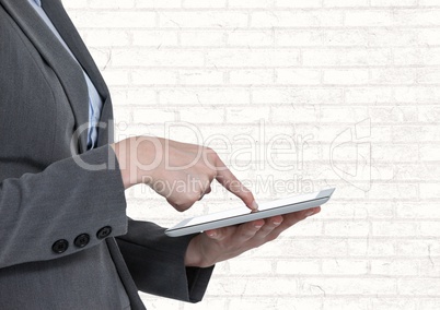 Man touching tablet with white brick wall