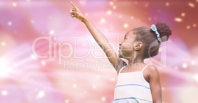 Little girl pointing away against blur background