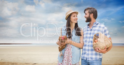 Happy couple carrying chicken and eggs at beach