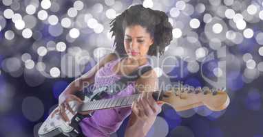 Music artist playing guitar against defocused lights