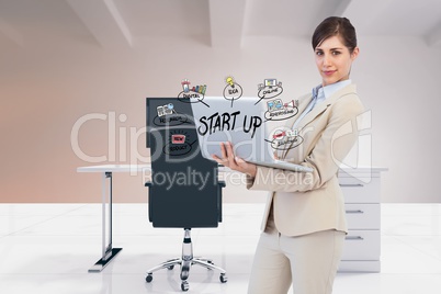 Digital composite image of businesswoman using laptop with start up text and icons in office