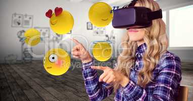 Woman trying to touch emojis while wearing VR glasses