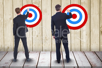 Full length rear view of businessmen setting targets on wooden wall
