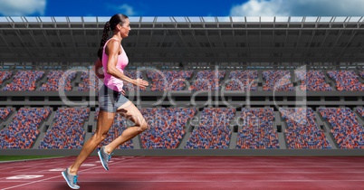 Sportswoman running on tracks against buildings