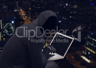 Anonymous Criminal Man in hood on laptop in front of night city