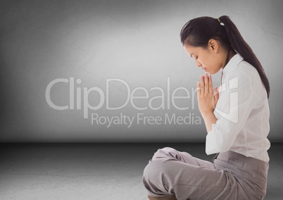 Business woman with praying in grey room