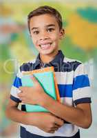 Boy holding books against blurry map