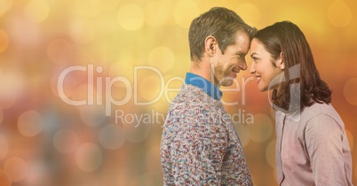 Side view of couple with head to head over bokeh background
