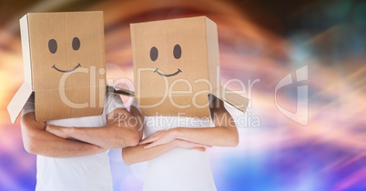 Couple wearing cardboard boxes on head with smileys drawn on it