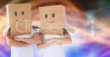 Couple wearing cardboard boxes on head with smileys drawn on it