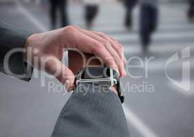 Hand with watch against blurry street with people