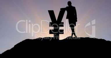 Silhouette businesswoman leaning on yen sign against sky