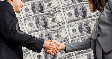 Business people shaking hands with dollars in background