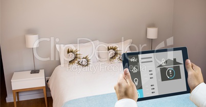 Hands using smart home app on tablet PC in bedroom
