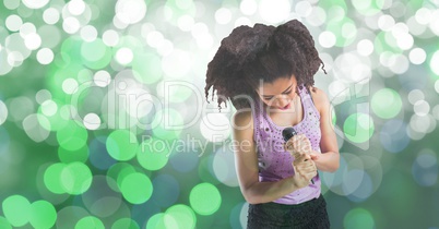 Young woman singing into microphone against bokeh background