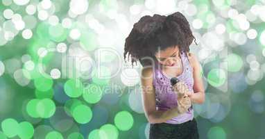 Young woman singing into microphone against bokeh background