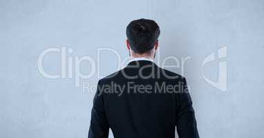 Rear view of businessman standing against blue background