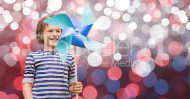 Happy boy holding pinwheel against bokeh