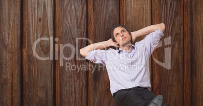 Thoughtful businessman over wooden wall