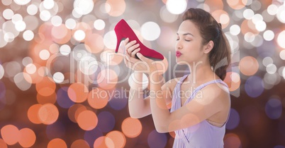 Young woman kissing new footwear over bokeh