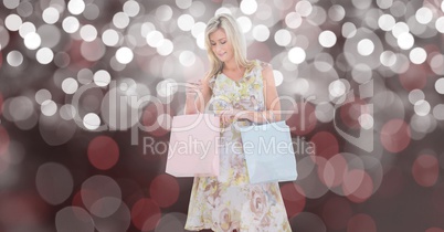 Woman looking at shopping bag over blur background