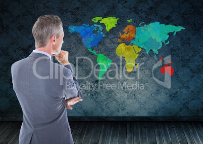 Businessman thinking looking at Colorful Map with wall room background