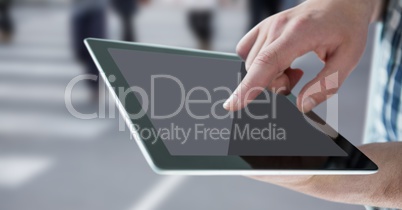 Hand with tablet against blurry street people