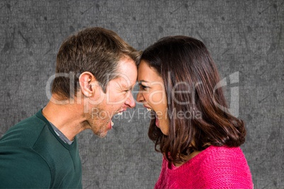 Side view of couple shouting while fighting against gray background