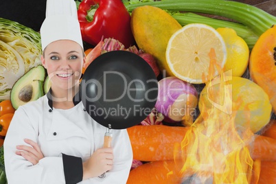 Portrait of chef holding cooking pan with vegetables in background