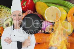 Portrait of chef holding cooking pan with vegetables in background