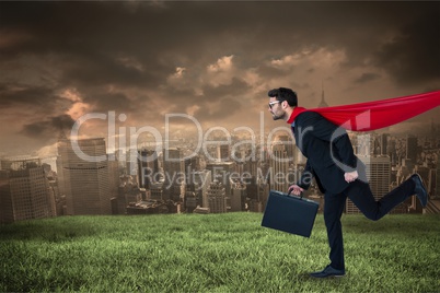 Digital composite image of businesswoman wearing cape running on field against city