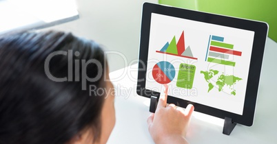 Cropped image of person using digital tablet with various graphs and charts on screen at table